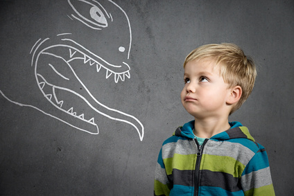 Un enfant qui regarde un mur avec dessiné dessus des cauchemards