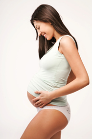 Femme enceinte de profil qui regarde son ventre